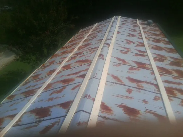Rusted metal roof panels with new wood purlins before replacement — Storm Damage Roof Repair in Sevier by Roofing Brothers