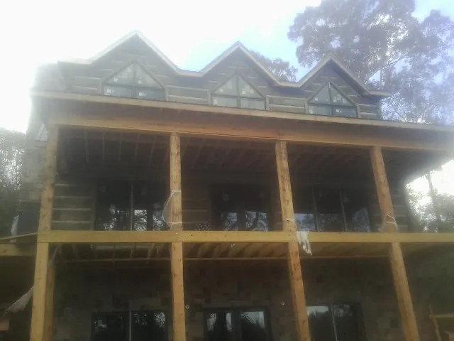 Dormers and porch framing on a large log home under construction — Roof Coating work by our crew in Sevier